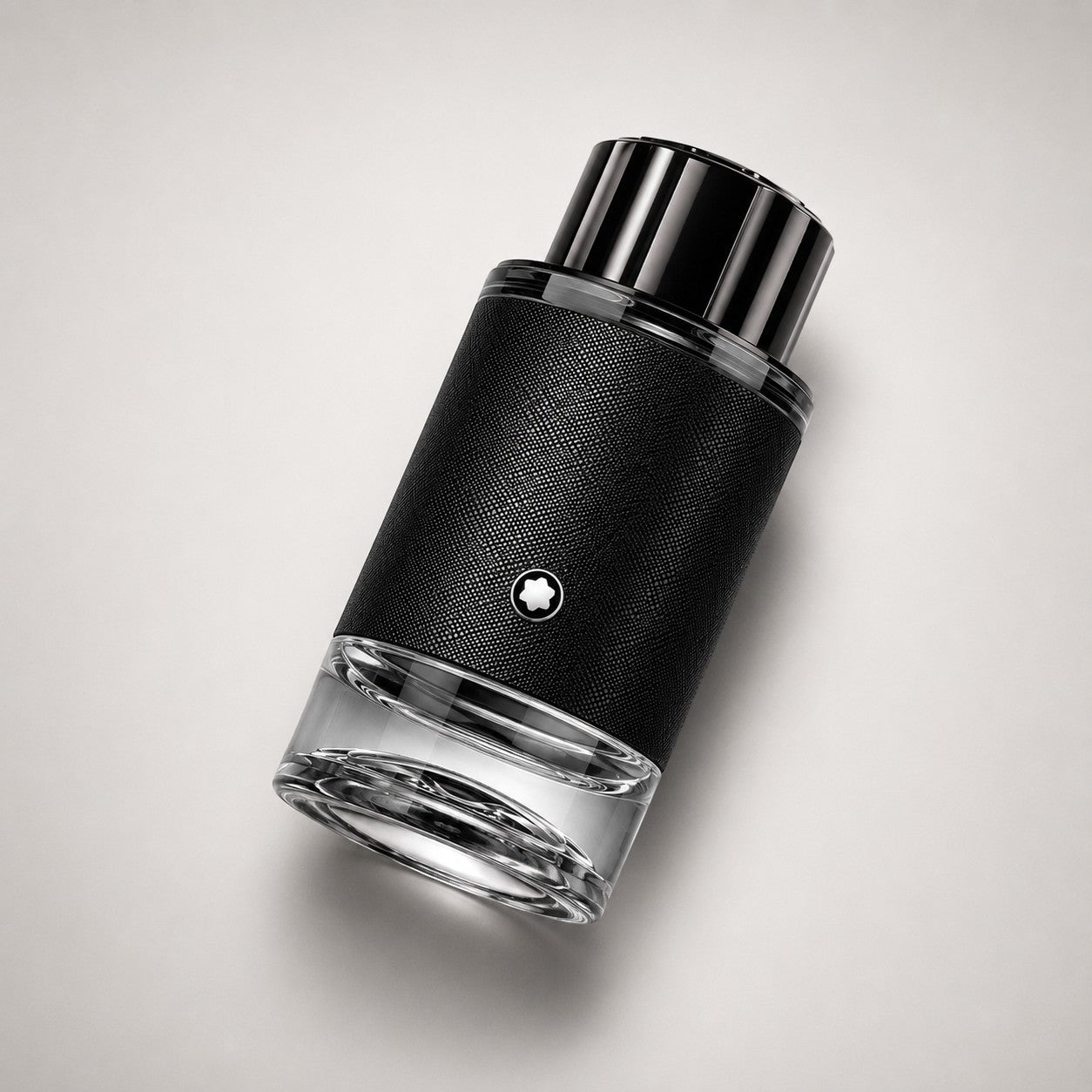 Frasco de perfume Montblanc Explorer de Ricky Luxury con diseño cilíndrico, textura de cuero negro y base de cristal