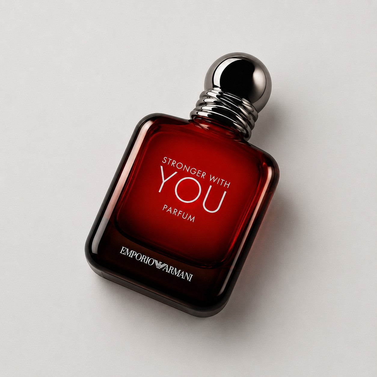 Perfume Emporio Armani Stronger With You Parfum en frasco de cristal rojo oscuro con tapón metálico de Ricky Luxury