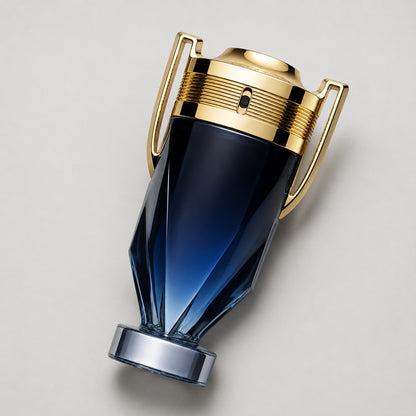 Perfume Paco Rabanne Invictus Parfum en frasco con forma de trofeo azul degradado y detalles dorados de Ricky Luxury