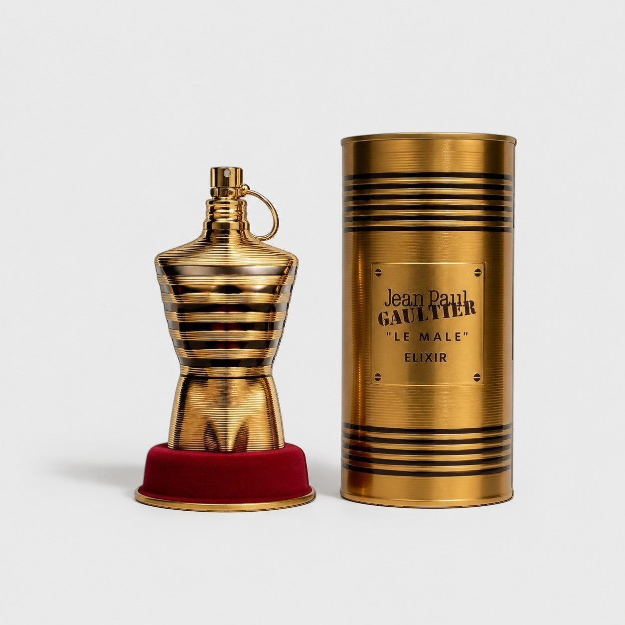 Perfume Jean Paul Gaultier Le Male Elixir en frasco dorado con forma de torso y estuche cilíndrico de Ricky Luxury