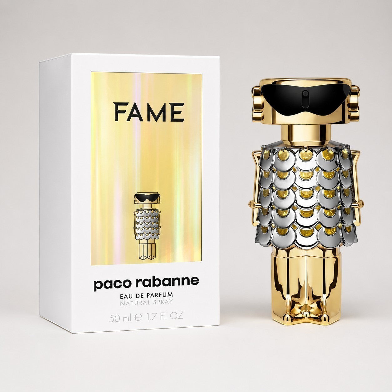 Perfume Paco Rabanne Fame de Ricky Luxury con frasco dorado y plateado en forma de robot junto a su caja original.