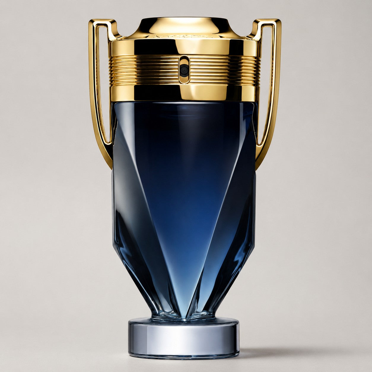 Frasco de perfume Paco Rabanne Invictus Parfum con diseño de trofeo en cristal azul oscuro y detalles dorados Ricky Luxury