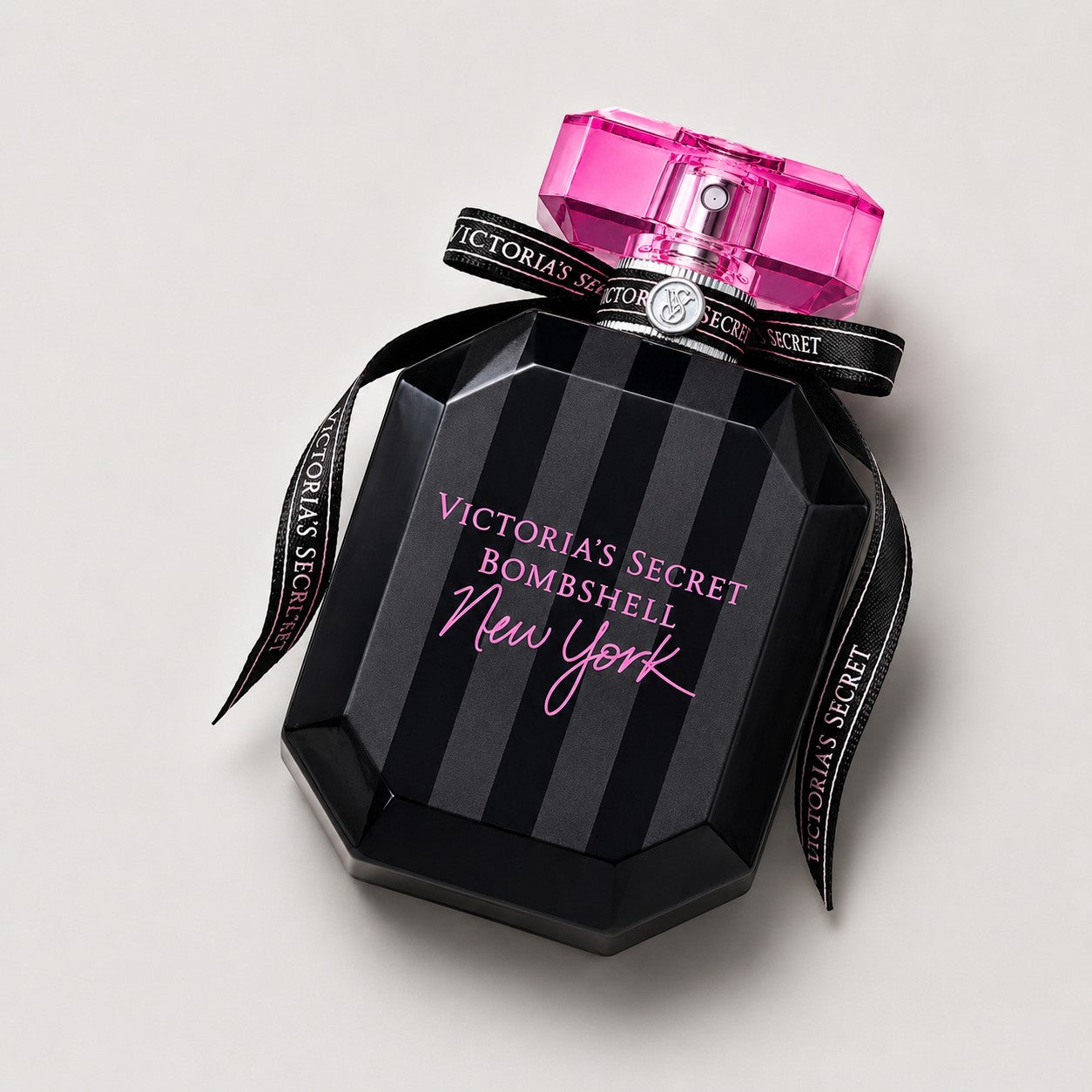 Perfume Victoria's Secret Bombshell New York de Ricky Luxury en frasco negro a rayas con lazo y tapón rosa brillante