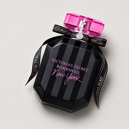 Perfume Victoria's Secret Bombshell New York de Ricky Luxury en frasco negro a rayas con lazo y tapón rosa brillante