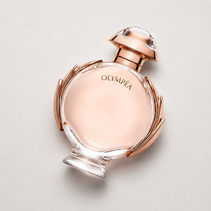 Frasco de perfume Paco Rabanne Olympea de Ricky Luxury con diseño circular en tono oro rosa y cristal transparente