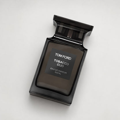 Frasco de perfume Tom Ford Tobacco Oud de Ricky Luxury en vidrio oscuro con etiqueta elegante sobre fondo neutro