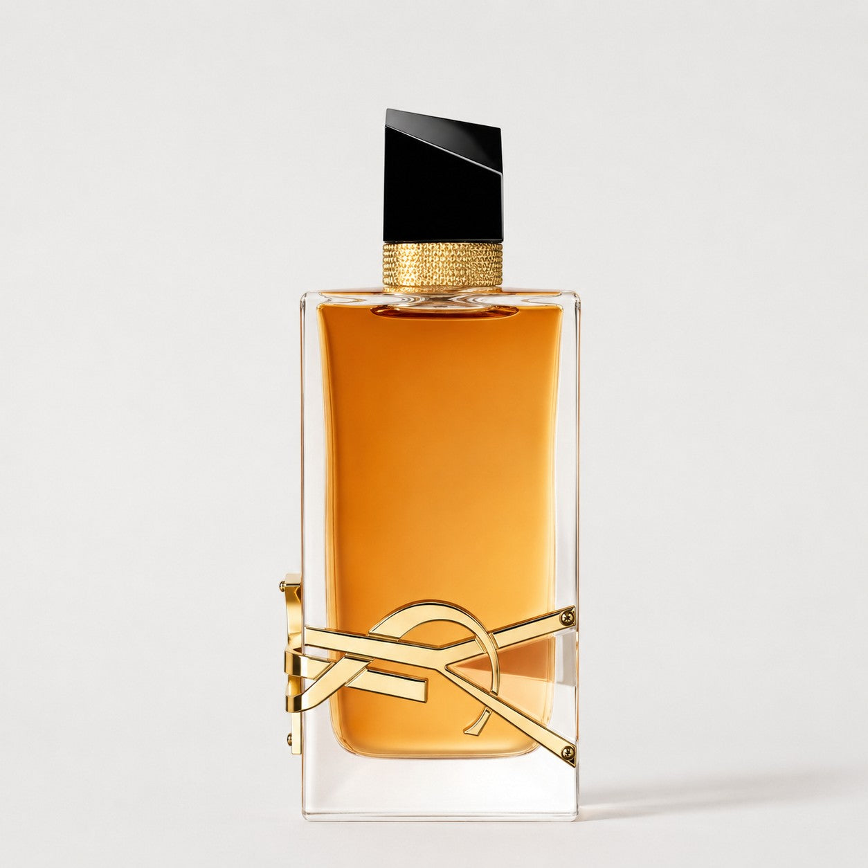 Frasco de perfume Ricky Luxury Yves Saint Laurent Libre con líquido ámbar, tapón negro y logo dorado icónico